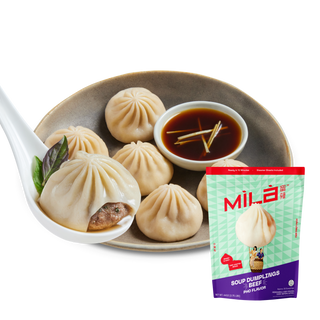 Front view of Beef Pho Soup Dumplings showcasing dumplings, dipping sauce, and package on a transparent background